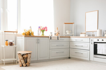 Interior of modern kitchen with stylish counters and beautiful flowers