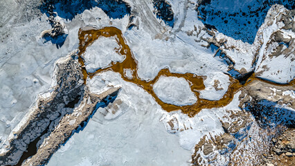 Aerial over melting snow at rock quarry