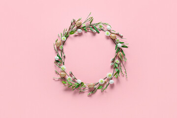 Beautiful wreath with Easter eggs and flowers on pink background