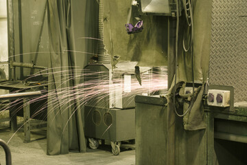 Sparks from the grinder behind the desk.