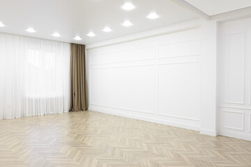 Empty room with white wall, wooden floor and spot lamps on ceiling