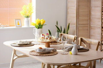 Festive dinnerware on table served for Easter celebration in room