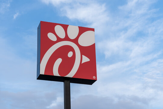 New Orleans,  Louisiana, USA- February 12, 2022: A Chick-fil-A logo pole sign with blue sky in background. Chick-fil-A is one of the largest American fast food restaurant chains.