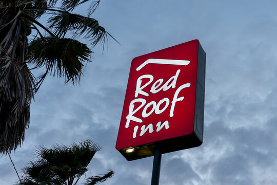 Baton Rouge,  Louisiana, USA- February 12, 2022: A Red Roof Inn Logo Pole Sign With Blue Sky In The Background At Dusk. Red Roof Inn Is An American Economy Hotel Chain. 