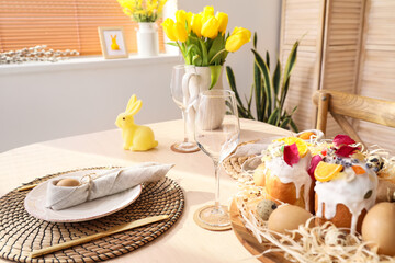 Stand with Easter cakes and eggs on served dining table