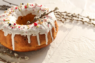 Tasty Easter cake and pussy willow branches on light background, closeup