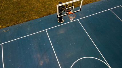Blue Basketball court with clear hoop and grassy backkground