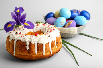 Tasty Easter cake with eggs and flower on grey background