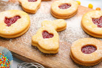 Board with delicious Easter cookies on light background