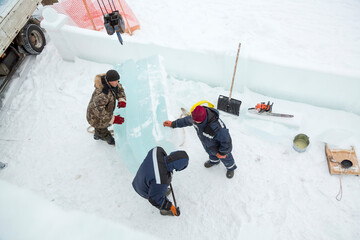 Portrait of fitters unloading ice blocks with truck crane