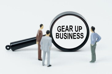 On a white background, figures of businessmen and a magnifying glass with the inscription - Gear Up Business