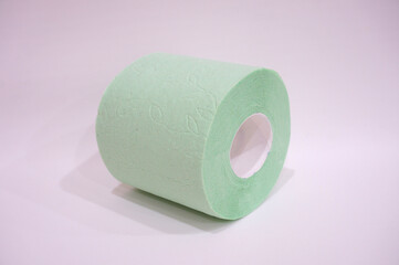 Roll of green toilet paper with a pattern on a light background