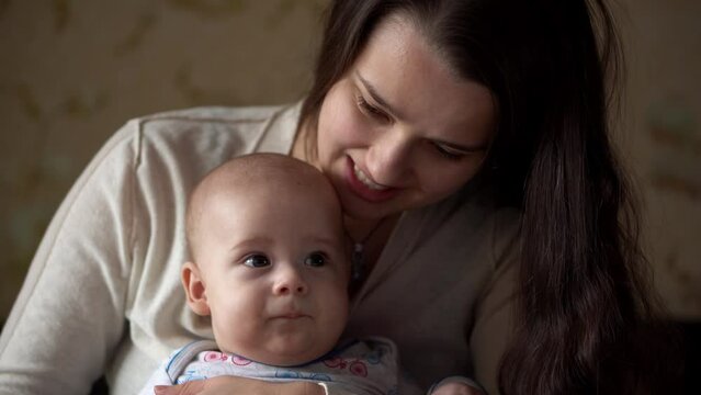 Newborn Active Baby With Young Mom. Cute Smiling Teethless Face Portrait Early Days On Stomach Developing Neck Control. Mother Kissing With Child Look At Camera. Infant, Childbirth, Beginning Concept
