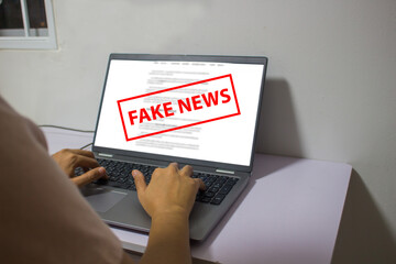 Laptop computer showing its screen with Fake news.