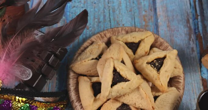 Jewish carnival Purim celebration on hamantaschen cookies, noisemaker and mask with top view from above.