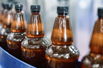 Plastic bottles with light filtered beer on the conveyor. Industrial production of beer.