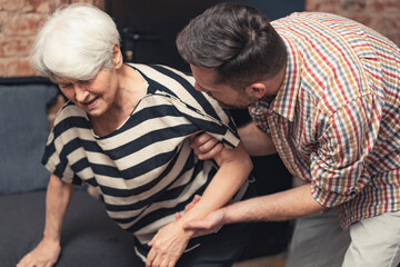 terrified grandmother having a panic attack held by her caucasian middle-aged son. High quality photo