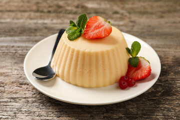 Delicious semolina pudding with berries on wooden table