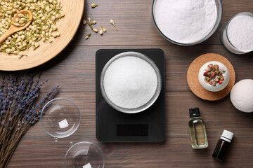 Handmade bath bombs and ingredients on wooden table, flat lay
