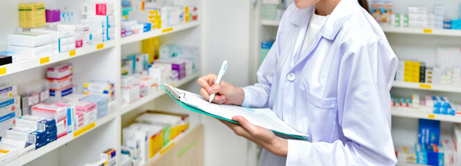 Asian woman pharmacist filling prescription in pharmacy drugstore