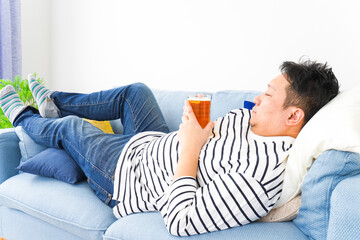 自宅でビールを飲む中年の男性