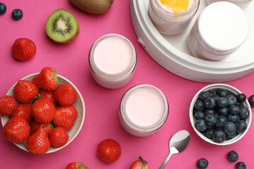 Obraz na płótnie Canvas Yogurt maker with jars and different fruits on pink background, flat lay