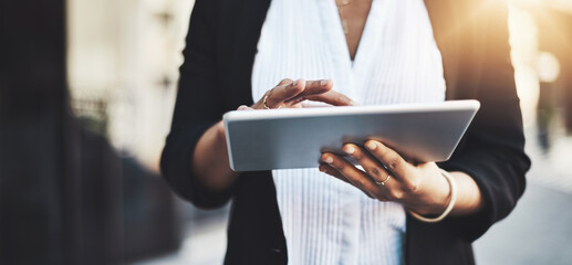 Get tapped right in to a world of success. Closeup shot of a businesswoman using a digital tablet in the city.