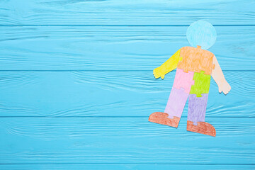Colorful human figure on color wooden background. Concept of autistic disorder