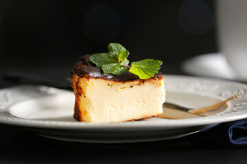 Plate with slice of tasty Basque burnt cheesecake on table, closeup