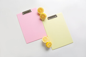 Blank clipboards and lemons on white background