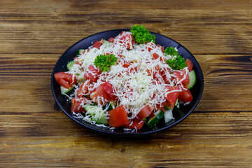 Traditional Bulgarian Shopska salad on wooden table