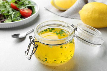 Jar with lemon sauce on light table. Delicious salad dressing