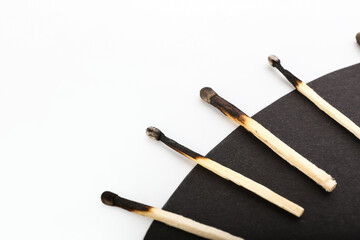 Burnt matches on white and black background, closeup. Concept of work burnout