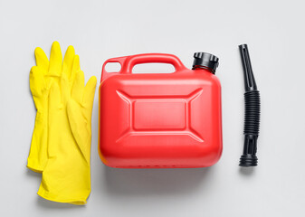 Plastic canister, rubber nozzle and rubber gloves on light background