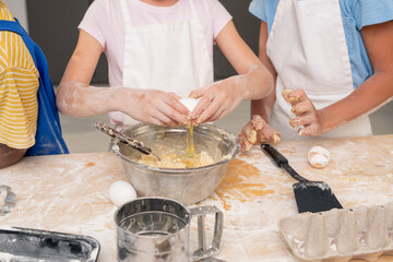Kids gathered together at modern kitchen and studying recipe of delicious dessert while thinking over festive menu for Mothers Day