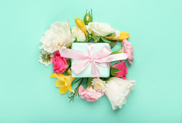 Beautiful spring composition with flowers and gift box on green background