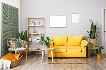 Interior of modern living room with yellow sofa, coffee tables and houseplants