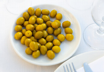 Pickled olives with a stone - a typical Spanish tapas in a white plate.....