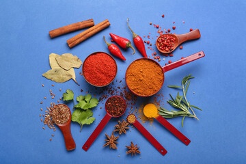 Fototapeta na wymiar Composition with aromatic spices and herbs on blue background