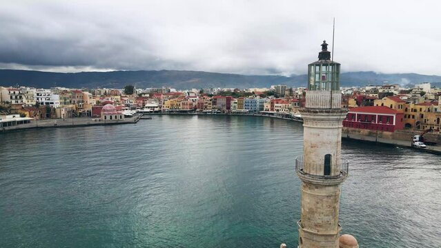 Tracking shot of chania city beyond the harbour's lighthouse in greece