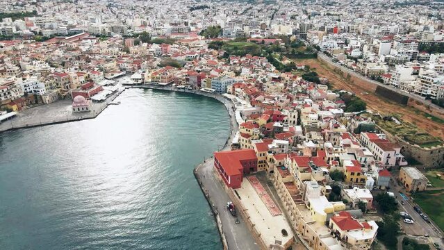Retreating aerial shot of chania city overlooking calm sea in greece