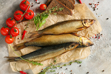Smoked herring fishes and bread on grey background