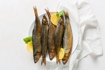 Plate with smoked herring fishes on white background
