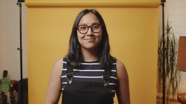 Asian woman claps a blank slate in home studio