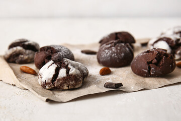 Parchment with chocolate brownie cookies on light background