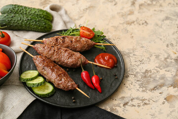 Plate of skewers with tasty lula kebab on beige background