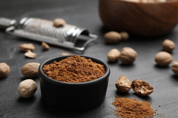 Nutmeg powder and seeds on black table