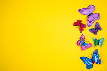 Decorative butterflies on a bright yellow background. The concept of the spring-summer season.