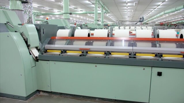Technical automation in textile factory - Thread machine used in the production of the clothing industry. Closeup shot of an electronic machine working in a cloth manufacturing workshop - technolog...