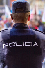 Hes got the situation under control. Rearview shot of a policeman wearing a uniform with the word, POLICIA on the back.
